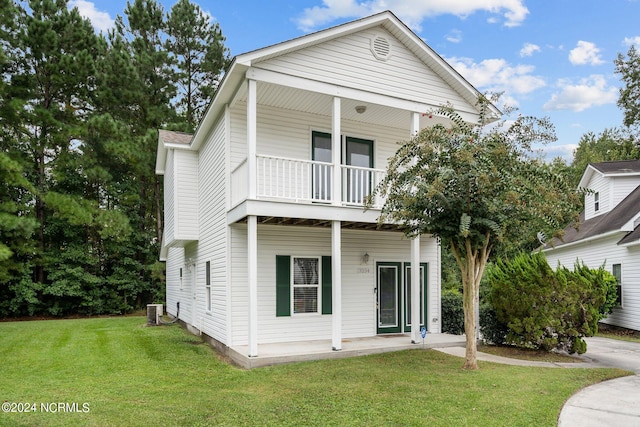 view of front facade featuring a balcony, central AC, and a front yard