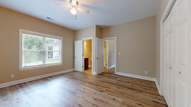 unfurnished bedroom with a closet, wood-type flooring, and ceiling fan