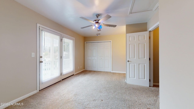 unfurnished bedroom featuring light carpet, ceiling fan, and a closet