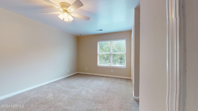 empty room featuring ceiling fan and light carpet