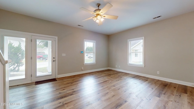 doorway to outside with a healthy amount of sunlight, ceiling fan, and light wood-type flooring