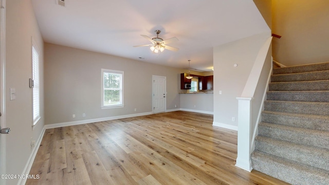 unfurnished living room featuring hardwood / wood-style flooring and ceiling fan