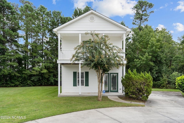 view of front of home with a front lawn and a balcony