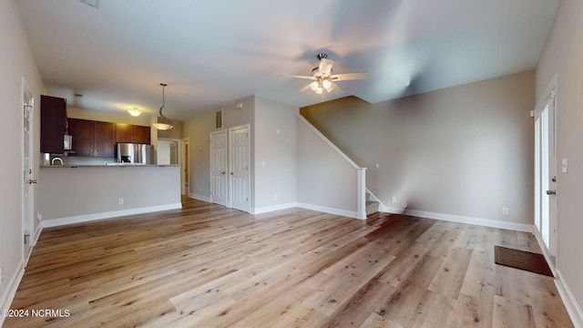 interior space with ceiling fan and light hardwood / wood-style floors