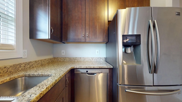 kitchen with appliances with stainless steel finishes and light stone countertops