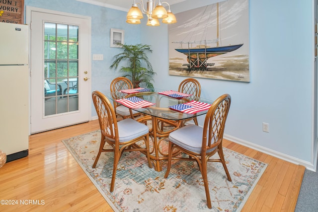 dining room featuring ornamental molding, an inviting chandelier, and hardwood / wood-style floors