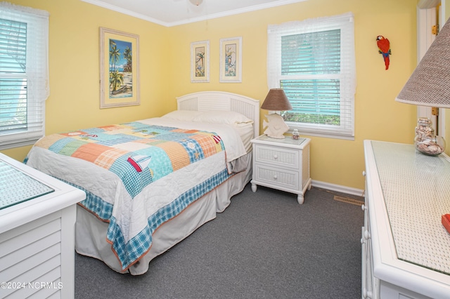 carpeted bedroom with ceiling fan and ornamental molding