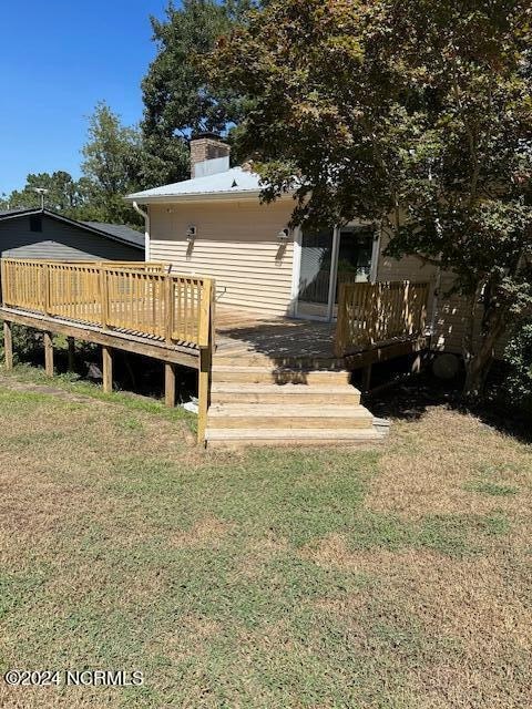 back of property with a yard and a deck