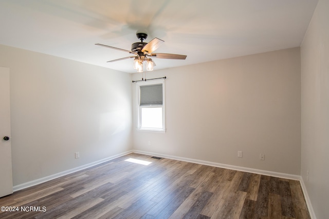 empty room with ceiling fan and dark hardwood / wood-style floors