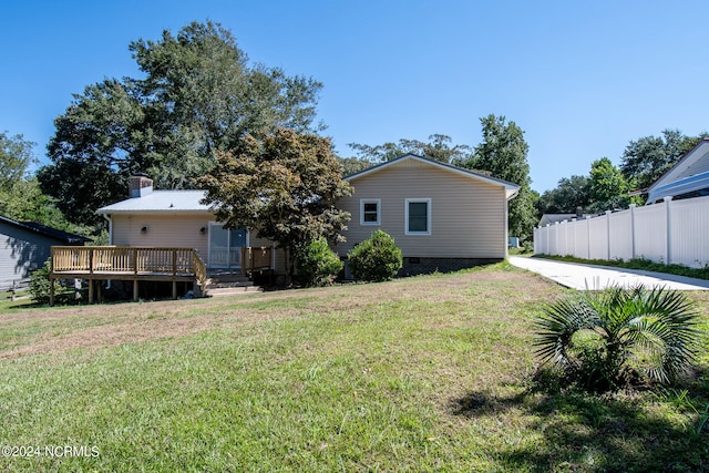 back of property with a lawn and a wooden deck