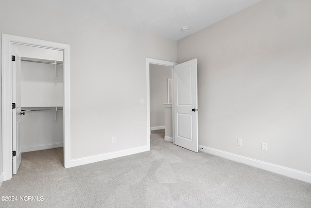 unfurnished bedroom featuring a closet and light carpet