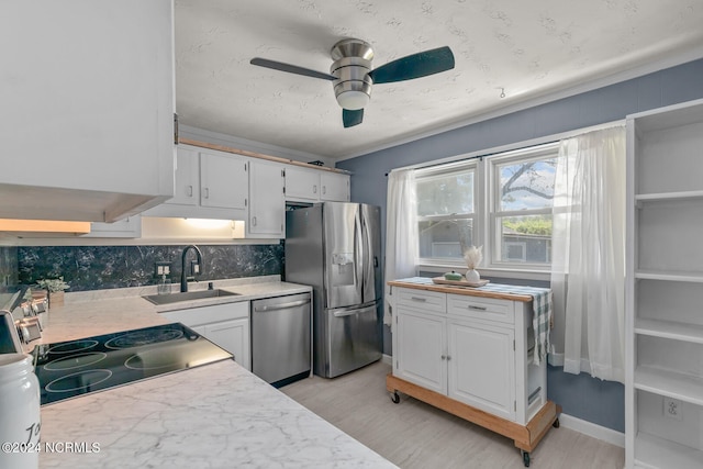 kitchen with stainless steel appliances, decorative backsplash, sink, white cabinets, and ceiling fan