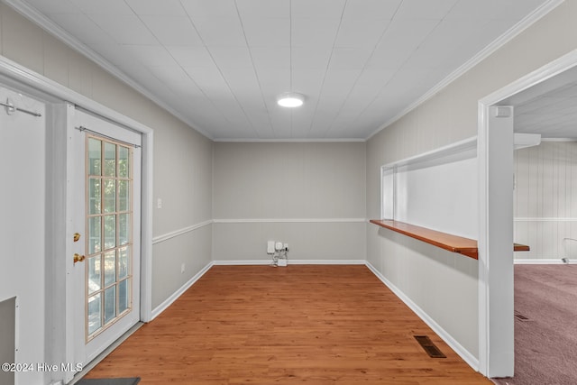 empty room featuring hardwood / wood-style floors and crown molding