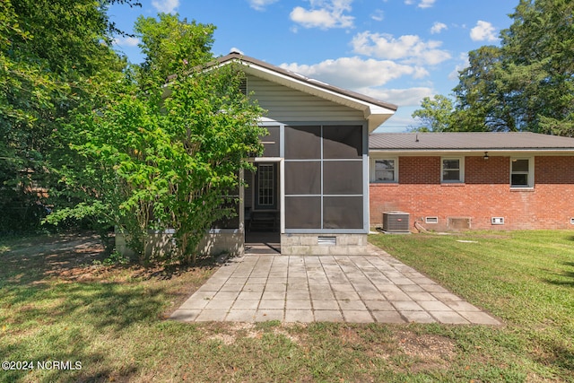 back of house with a sunroom, a yard, central AC, and a patio area