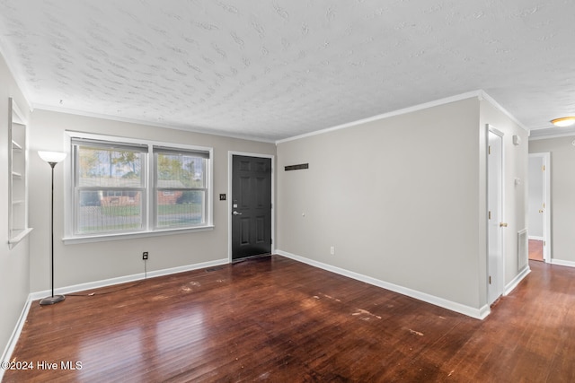 spare room with dark wood-type flooring, a textured ceiling, and crown molding