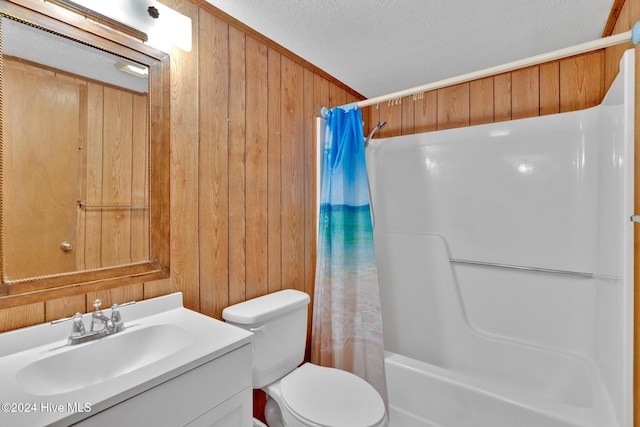 full bathroom featuring shower / bath combo, vanity, a textured ceiling, wooden walls, and toilet