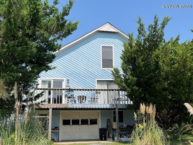 back of house with a garage and a deck