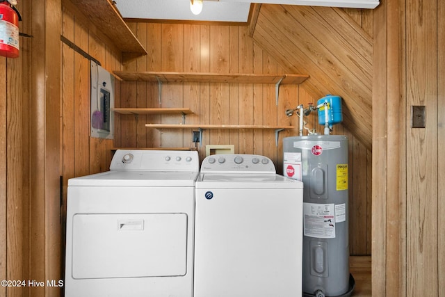 laundry area with washing machine and dryer, electric water heater, and wooden walls