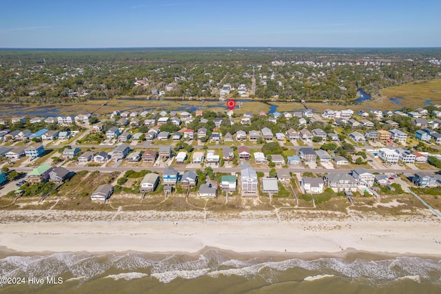 birds eye view of property featuring a water view and a beach view