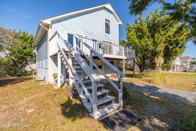 back of property featuring a yard and a wooden deck