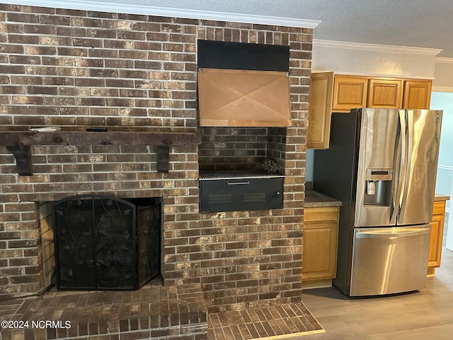 kitchen with ornamental molding, hardwood / wood-style floors, stainless steel fridge with ice dispenser, and a textured ceiling