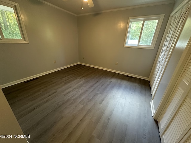 unfurnished bedroom featuring a closet, crown molding, dark hardwood / wood-style flooring, and ceiling fan