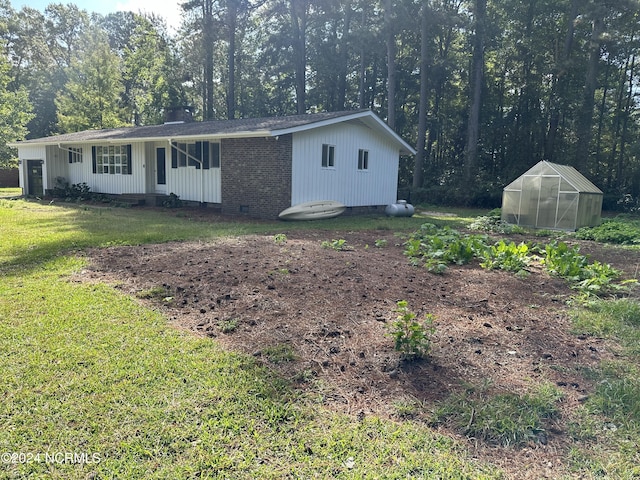 view of front of house featuring a front yard and a storage unit