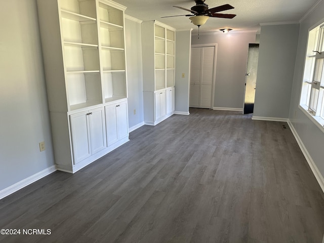 interior space featuring dark wood-type flooring, ornamental molding, a textured ceiling, and ceiling fan