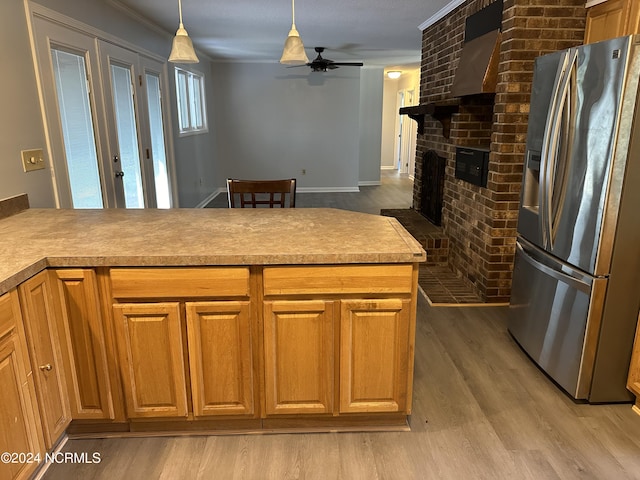 kitchen featuring ceiling fan, light hardwood / wood-style floors, a fireplace, hanging light fixtures, and stainless steel fridge with ice dispenser