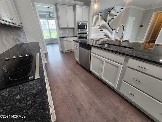 kitchen with stainless steel appliances, dark stone countertops, white cabinetry, and sink