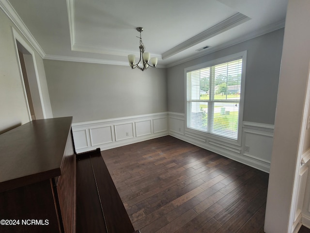 unfurnished dining area with ornamental molding, a notable chandelier, a raised ceiling, and dark hardwood / wood-style flooring