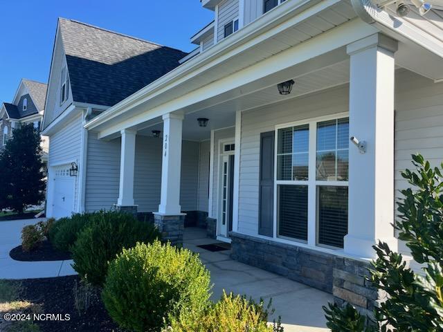 view of exterior entry with covered porch and a garage