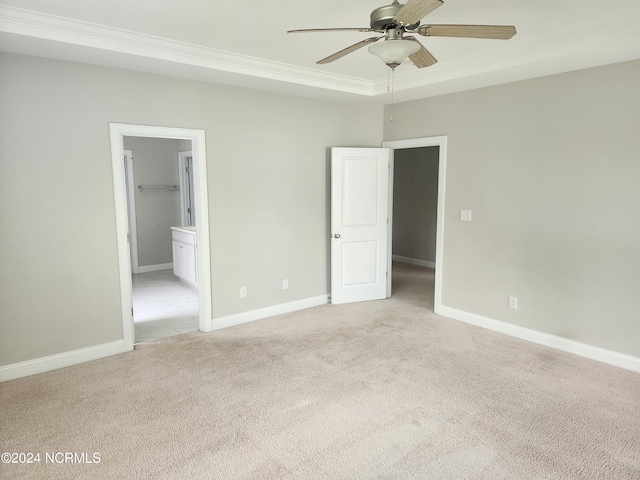 unfurnished bedroom with a spacious closet, a closet, ceiling fan, ornamental molding, and light carpet