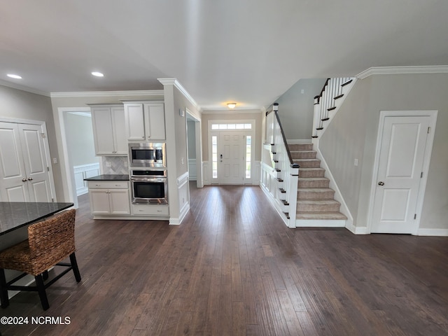 foyer entrance featuring ornamental molding and dark wood-type flooring