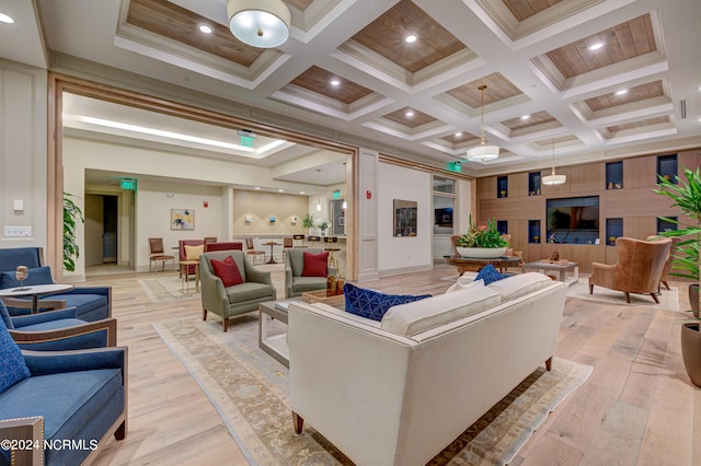 living room featuring beam ceiling, light wood-type flooring, ornamental molding, and coffered ceiling