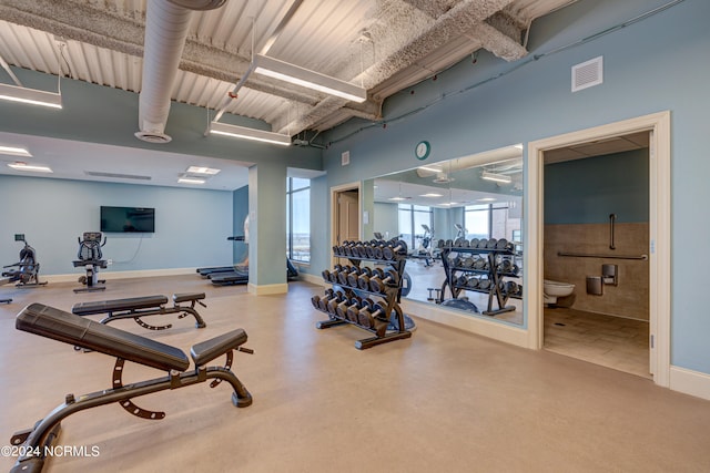 workout area featuring a towering ceiling