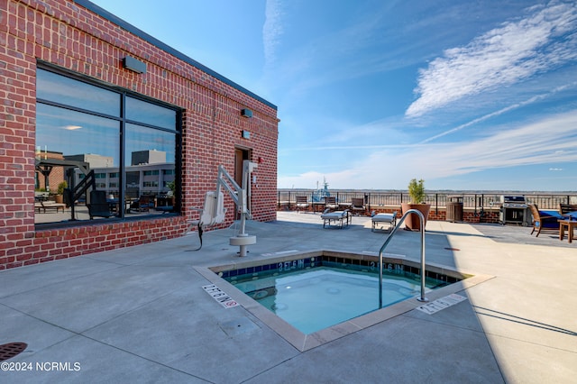 view of swimming pool featuring a patio area and a community hot tub