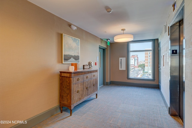 hallway featuring light carpet and elevator