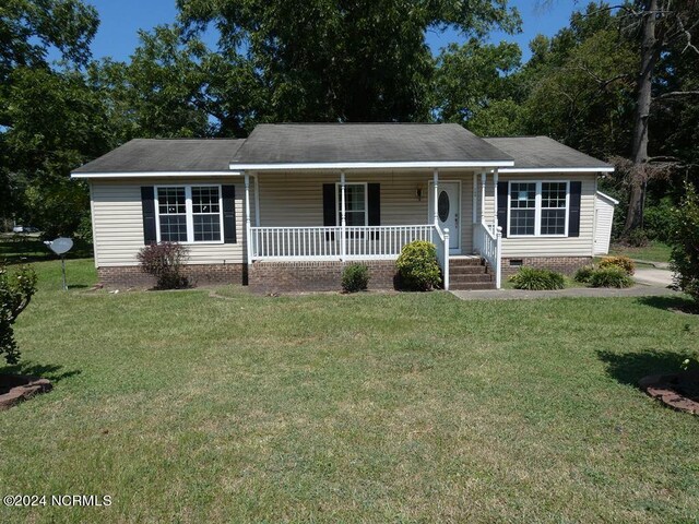 ranch-style house with a front yard and covered porch