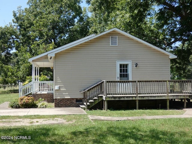 rear view of property featuring a lawn