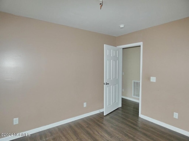 empty room with dark hardwood / wood-style flooring