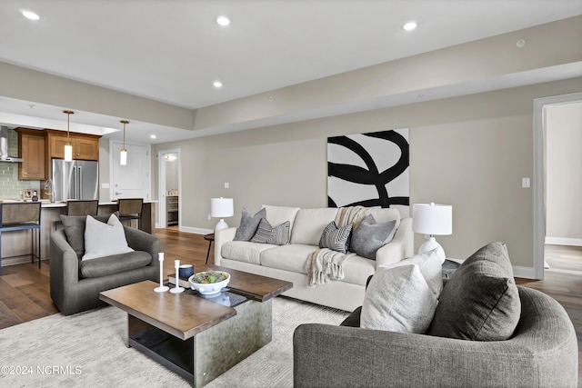 living room with recessed lighting, baseboards, and wood finished floors