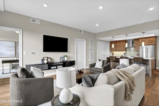 living room featuring baseboards, dark wood-style flooring, visible vents, and recessed lighting