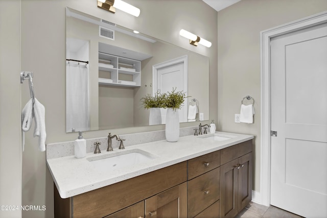 bathroom with double vanity, a sink, tile patterned flooring, and visible vents