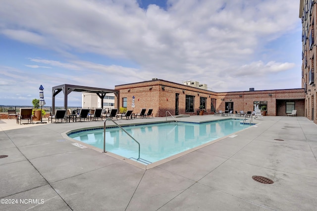 community pool featuring fence and a patio