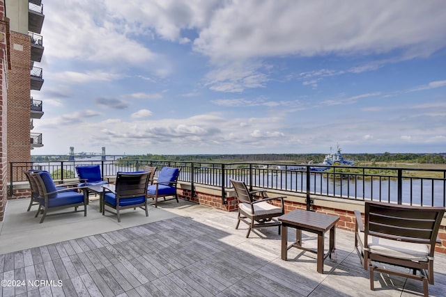 deck with an outdoor living space and a water view