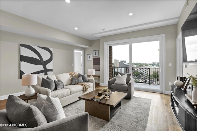 living area with baseboards, visible vents, recessed lighting, and light wood-type flooring