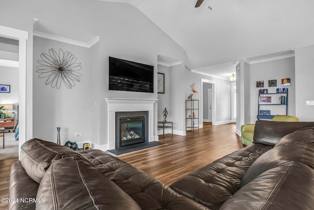 living room with ceiling fan, hardwood / wood-style flooring, crown molding, and vaulted ceiling