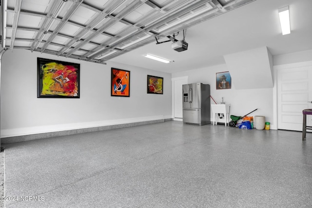 garage with stainless steel fridge and a garage door opener