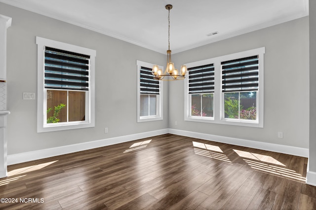 spare room featuring a notable chandelier, crown molding, and dark hardwood / wood-style flooring